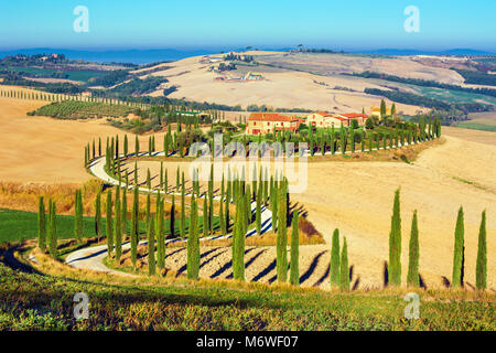 Crete Senesi, Toscane, Italie. Une ferme isolée de cyprès et d'oliviers, collines, Toscane, Italie. Banque D'Images