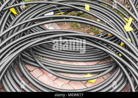 Les câbles en plastique enroulé allongé sur sol en brique Banque D'Images
