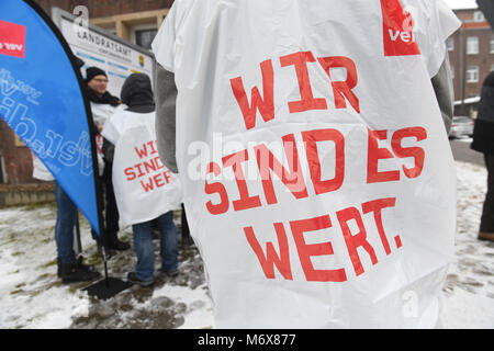 07 mars 2018, l'Allemagne, Stralsund : l'écriture sur la bavette se lit comme suit : "Nous sommes en valeur elle' comme le personnel de la fonction publique se rassembler devant le bureau de district du comté de Bavière et Ruegen pour une grève d'avertissement. La première ronde de négociations salariales pour l'ensemble du pays 2, 3 millions d'employés de la fonction publique a pris fin sans qu'une offre de service public employeurs il y a plus d'une semaine. Photo : Stefan Sauer/dpa Banque D'Images