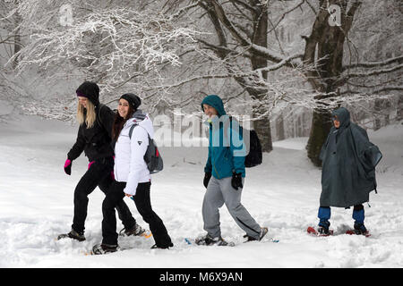 Subiaco, Italie - Février 25, 2018 : au milieu de l'hiver, quatre amis randonnée sur la montagne enneigée, raquettes pour éviter de tomber dans la profonde Banque D'Images