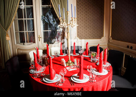 Servi table en rouge et blanc avec des chandeliers et des bougies bleu décoré avec web imitation en style gothique sur banquet service traiteur Banque D'Images