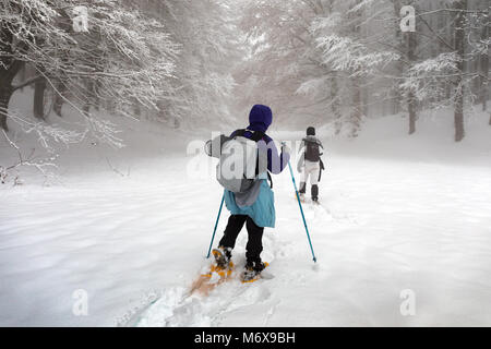 Subiaco, Italie - Février 25, 2018 : au milieu de l'hiver, deux personnes prennent une excursion sur la montagne couverte de neige, raquettes sur les droits qu'ils Banque D'Images