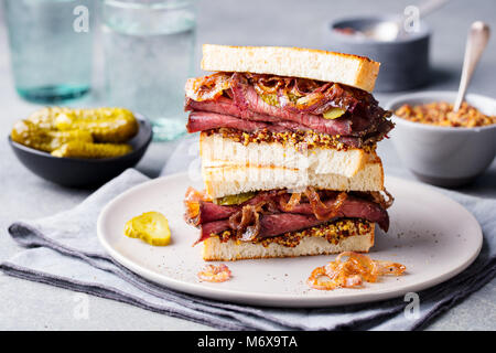 Sandwich au rôti de boeuf sur une plaque avec des pickles. Banque D'Images