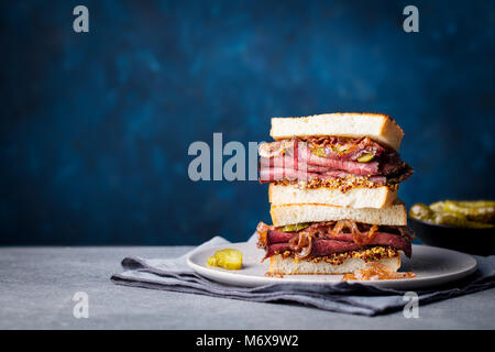 Sandwich au rôti de boeuf sur une plaque avec des pickles. Copier l'espace. Banque D'Images