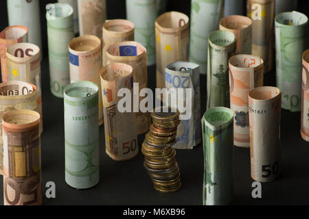 Pile de pièces en euro et des rouleaux de billets de banque dans l'arrière-plan Banque D'Images