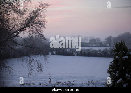 Une vue d'hiver au lever du soleil sur les champs couverts de neige en milieu rural England UK Worcestershire Banque D'Images