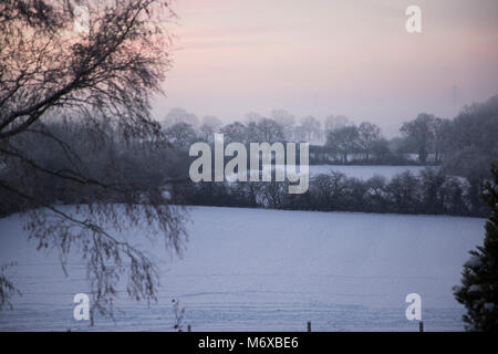 Une vue d'hiver au lever du soleil sur les champs couverts de neige en milieu rural England UK Worcestershire Banque D'Images