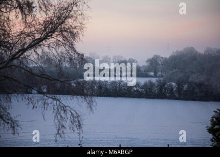 Une vue d'hiver au lever du soleil sur les champs couverts de neige en milieu rural England UK Worcestershire Banque D'Images