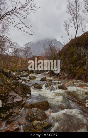 Un ruisseau dégringole au large de Rannoch Moor, et des chefs dans la rivière Etive à la tête de Glen Coe dans les Highlands écossais. Les eaux gonflé par la pluie récente Banque D'Images