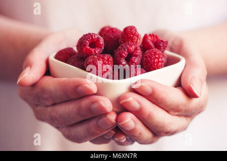 De la vaisselle avec des framboises dans femme mains, selective focus Banque D'Images