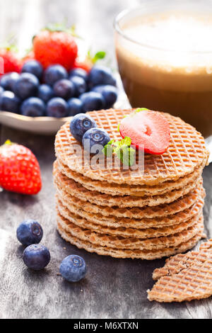 Pile de gaufres caramel néerlandais avec Blueberry et de fraise avec tasse de café Banque D'Images