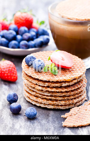 Pile de gaufres caramel néerlandais avec Blueberry et de fraise avec tasse de café Banque D'Images