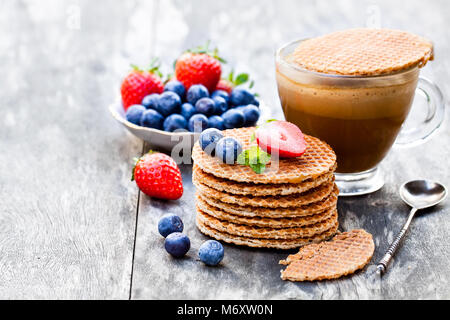 Pile de gaufres caramel néerlandais avec Blueberry et de fraise avec tasse de café Banque D'Images