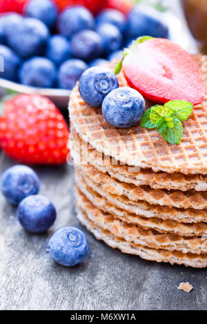 Pile de gaufres caramel néerlandais avec Blueberry et de fraise avec tasse de café Banque D'Images