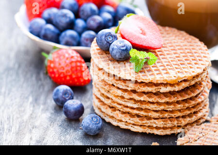 Pile de gaufres caramel néerlandais avec Blueberry et de fraise avec tasse de café Banque D'Images