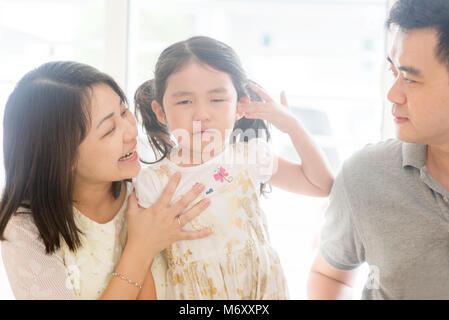 Les parents enfant pleurant réconfortant. La famille asiatique à la maison, mode de vie naturel à l'intérieur. Banque D'Images