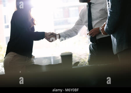 Des collègues de se serrer la main après un accord en réunion. Les gens d'affaires et de secousses chaque message d'autres après un accord. Banque D'Images