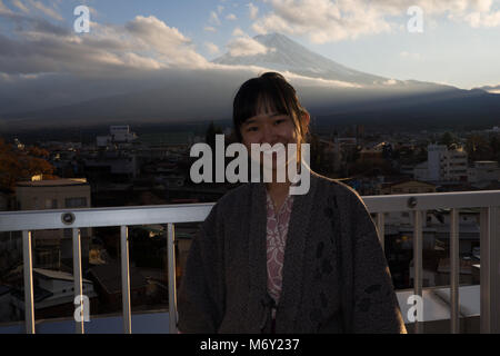 Belle fille dans un yukata avec la vue du Mont Fuji au coucher du soleil Banque D'Images