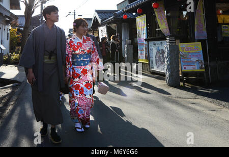 Un couple japonais habillé de tissu traditionnel de la marche dans le centre-ville de Beppu. Banque D'Images