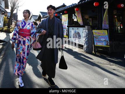 Un couple japonais habillé de tissu traditionnel de la marche dans le centre-ville de Beppu. Banque D'Images