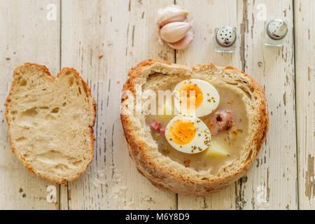 Soupe Zurek polonais traditionnel appelé avec des œufs et des saucisses sur fond de bois Banque D'Images