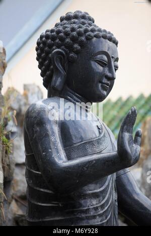 Une statue de Bouddha noire dans le parc de la pagode Linh Ung, Da nang, Vietnam Banque D'Images