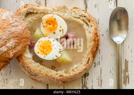 Soupe Zurek polonais traditionnel appelé avec des œufs et des saucisses sur fond de bois Banque D'Images