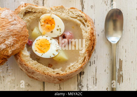 Soupe Zurek polonais traditionnel appelé avec des œufs et des saucisses sur fond de bois Banque D'Images