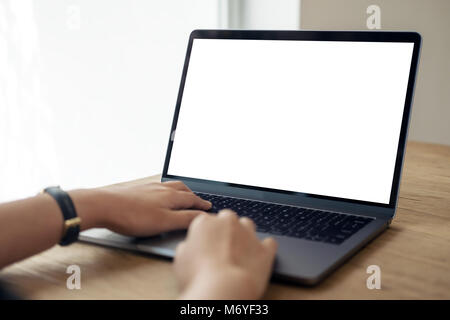 L'image de mains à l'aide de maquettes et de la saisie sur ordinateur portable avec écran de bureau blanche sur table en bois Banque D'Images