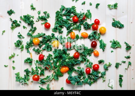 Chou vert et rouge avec les tomates cerise prune jaune sur fond de bois Banque D'Images