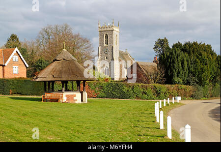 Une vue de l'église de St Fabian et St Sébastien et la couverts de chaume et de l'eau sur la place du village à Woodbastwick, Norfolk, Angleterre, Royaume-Uni. Banque D'Images