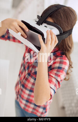 Vue de dessus de la pré-adolescence fille casque VR d'ouverture de coffre avant Banque D'Images