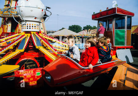 Les jeunes enfants sur un manège à kiddies Nottingham Goose Fair, un voyage annuel fête foraine s'est tenue à la Forest Recreation Ground à Nottingham, en Angleterre, au cours de la première semaine d'octobre. Photographie d'archives faites en octobre 1987, Angleterre Banque D'Images