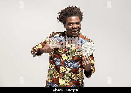 Portrait of African businessman kongo, détenant plusieurs espèces et sourire. Piscine, isolé sur fond gris Banque D'Images