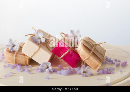 Les savons faits à la main, fleurs et de sel de mer sur table en bois Banque D'Images