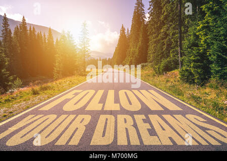 Suivez vos rêves texte écrit sur route dans les montagnes Banque D'Images