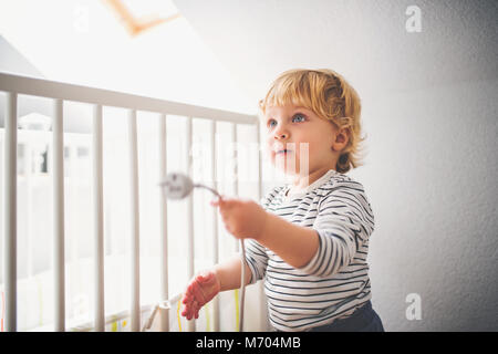 Bébé garçon dans une situation dangereuse à la maison. Banque D'Images