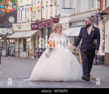 Couple nouvellement marié marchant dans la rue du soleil, Hitchin, Herts, UK Banque D'Images