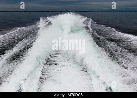 Grand service lumineux sur l'eau sombre d'un gros bateau puissant avec 4 moteurs V8. Banque D'Images