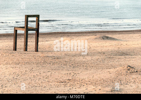 Grande chaise en bois debout sur la plage près de la côte Banque D'Images