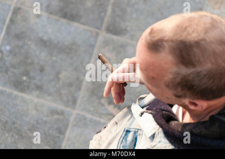 Homme avec un cigare à la main debout sur un square Banque D'Images