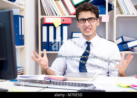 Employé attaché et enchaîné à son bureau avec chaîne Banque D'Images