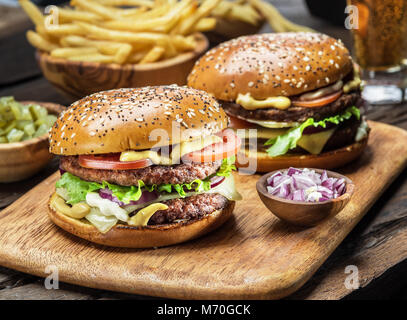 Les hamburgers et les frites sur le plateau en bois Banque D'Images