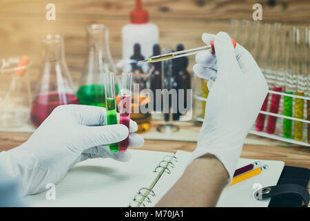 Chercheur est l'abandon le réactif en tube à essai.de travail scientifique au laboratoire. Banque D'Images