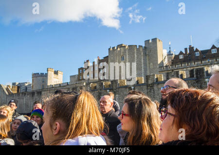 Les touristes se sont réunis l'écoute d'un guide d'excursion, beefeater Tour de Londres, Tower Hill, London UK concept touristique, les touristes à écouter un guide Banque D'Images