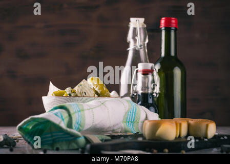 Photo horizontale avec plusieurs rouleaux de fromage fumé parenica mis sur rustique en bois foncé, les piments verts farcis de fromage aux herbes et par quelques b Banque D'Images