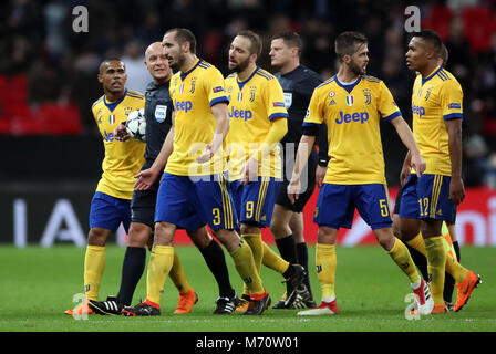 Les joueurs de la Juventus arbitre surround Szymon Marciniak à la mi-temps au cours de la Ligue des Champions tour de 16, deuxième match aller au stade de Wembley, Londres. Banque D'Images