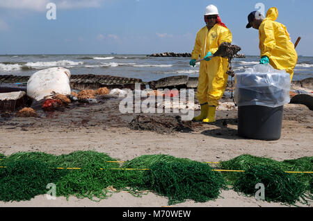 Santé, sécurité et environnement (SSE), les travailleurs à contrat par BP nettoyer huile sur une plage à Port Fourchon, en Louisiane, le 23 mai 2010. Des centaines de travailleurs sous contrat HSE sont le nettoyage de l'huile provenant de la marée noire Deepwater Horizon, qui a commencé à faire la vaisselle sur les plages de la région d'un mois après l'unité de forage a explosé. Banque D'Images