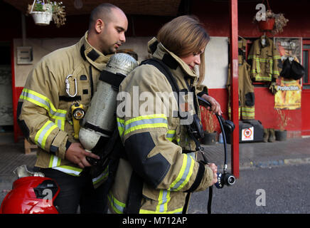 Beyrouth, Liban. 08Th Mar, 2018. Une photo disponible le 07 mars 2018 montre un pompier aider collègue Dalia Naamani (R), 40 ans, de mettre sur son réservoir d'oxygène pendant un exercice de défense civile du Liban à Beyrouth, Liban, 06 mars 2018. Il y a six ans Dalia, diplômé en informatique et d'une mère de deux enfants, a démissionné de son emploi pour être pompier. Le monde célèbre la Journée internationale de la femme 2018 le 08 mars. Credit : Marwan Naamani/afp/Alamy Live News Banque D'Images