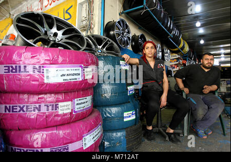 Beyrouth, Liban. 08Th Mar, 2018. Une photo disponible le 07 mars 2018 montre Amina Akouka (L), 24 ans, assise avec son collègue Abu Yazan à son lieu de travail à Beyrouth, Liban, 06 mars 2018. Amina, connu sous le nom de Roue 'Femme' parmi ses collègues masculins, a commencé à travailler dans l'entreprise de fixation des roues depuis qu'elle a été 15 en raison de sa passion pour les voitures et les motos. Le monde célèbre la Journée internationale de la femme 2018 le 08 mars. Credit : Marwan Naamani/afp/Alamy Live News Banque D'Images